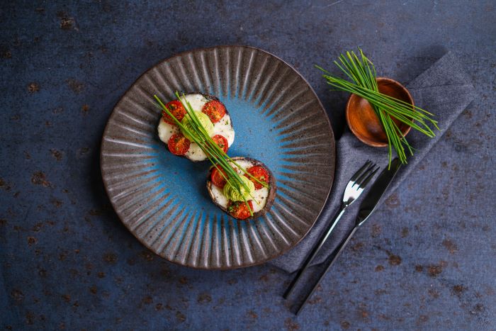 stuffed mushrooms garnished with wild onion party snack ideas placed on ceramic bowl