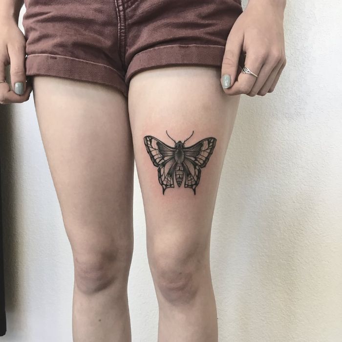 thigh tattoo on woman wearing jean shorts butterfly and flower tattoo black and white monarch butterfly