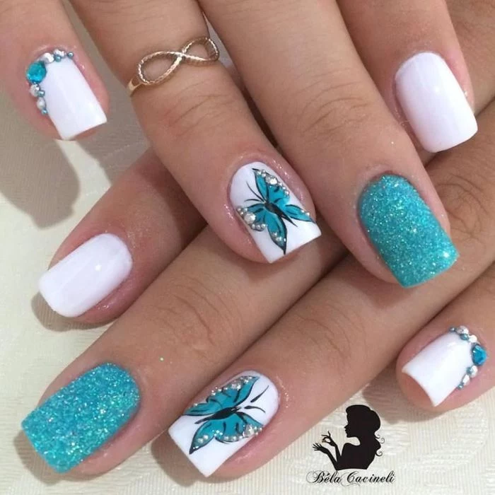 white nail polish base blue glitter blue rhinestones and butterflies decorations nail designs for short nails