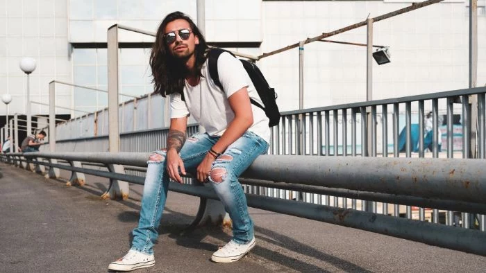 white t shirt with ripped jeans white converse sneakers worn by man with long black hair mens hip hop clothing