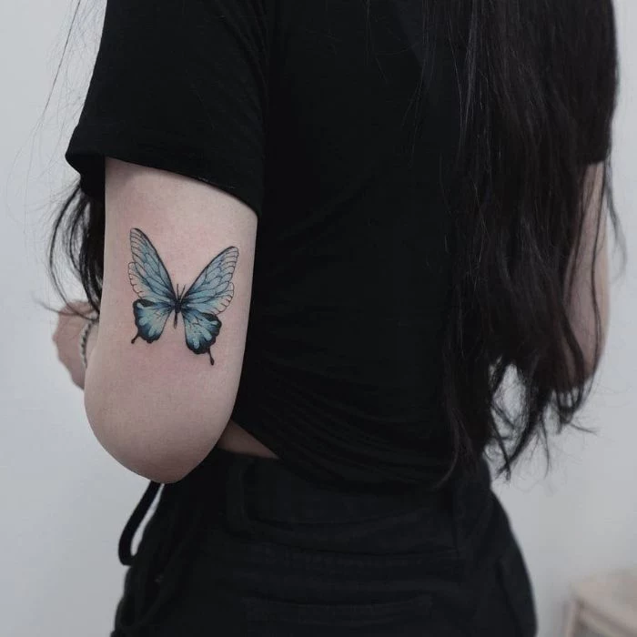 woman wearing black jeans and t shirt butterfly tattoo meaning back of arm blue butterfly tattoo