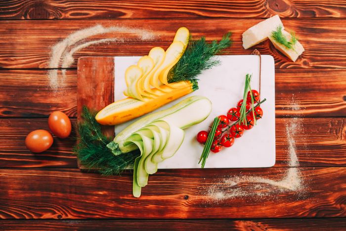 zucchini sliced placed on marble cutting board best appetizers to bring to a party wooden surface