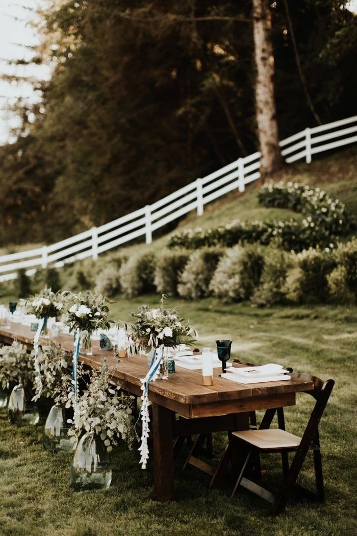 arrangements of flowers in front and on top of wood tablebackyard wedding placed on green grass field