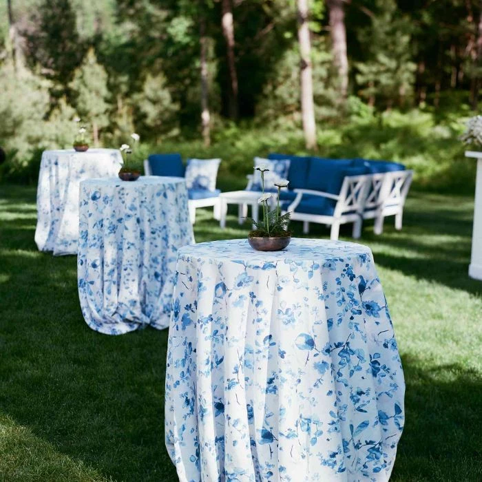 blue table cloths on tall tables with spring flowers in the middle rustic wedding ideas blue sofas in the background