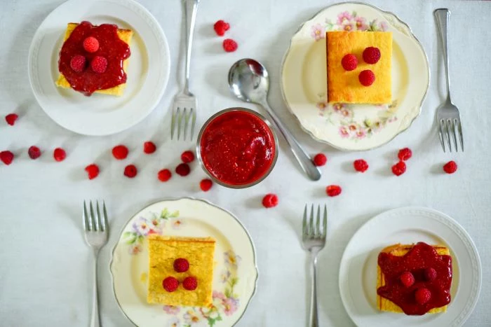 cake slices in four different plates zucchini and squash recipes garnished with raspberries and raspberry jam