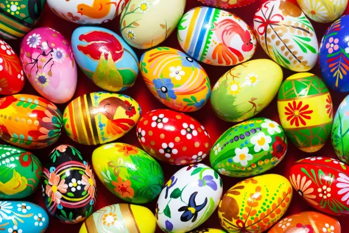 colorful eggs with different patterns and drawings on them dying easter eggs scattered on red surface