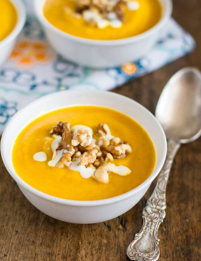 creamy summer squash soup zucchini and yellow squash recipes placed in white bowl with walnuts and cream