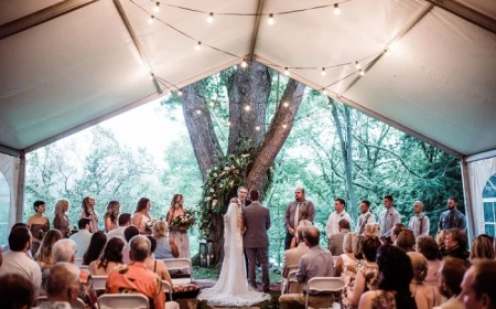 diy wedding ideas bride and groom standing in front of large tree tent set up in front of it