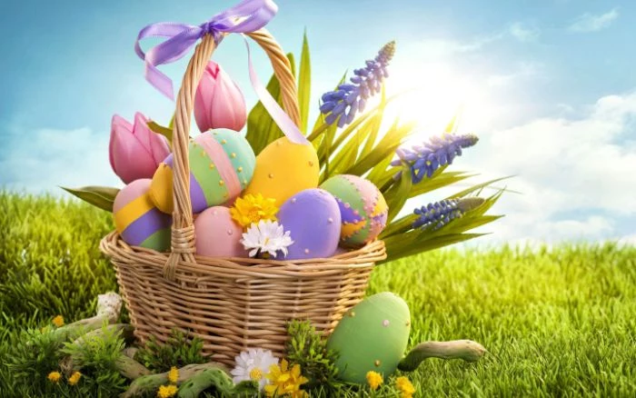 easter background basket filled with easter eggs in different colors and patterns and flowers