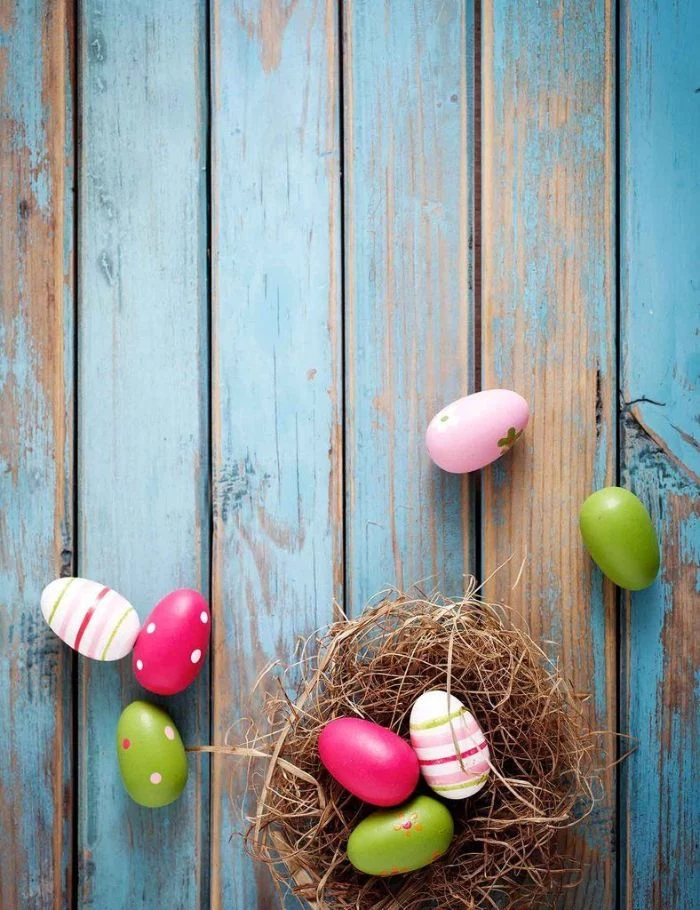 easter background free nest with eggs in different colors placed on blue wooden surface