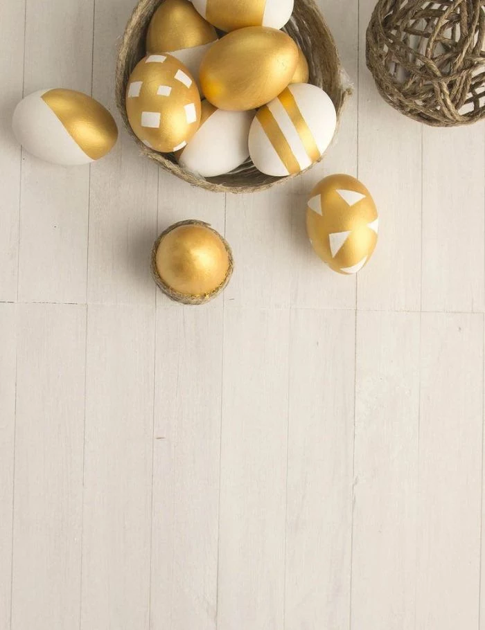 easter background images eggs dyed in gold and white placed in wicker basket on white wooden surface