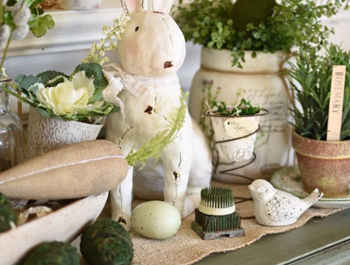 easter decorations ceramic bunny placed in the middle surrounded flowers in ceramic pots