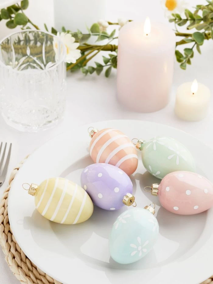 egg shaped baubles in different colors placed inside white plate diy easter decorations greenery table runner