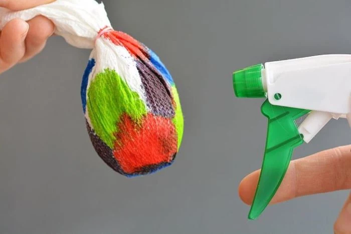 egg wrapped in paper towel soaked in different colors how to color easter eggs sprayed with water