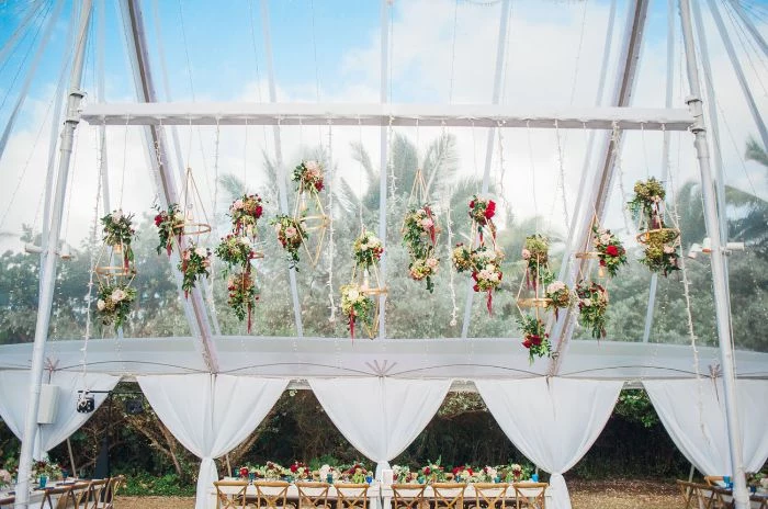 flower bouquets hanging from the ceiling of large tent outside wedding ideas long table under it