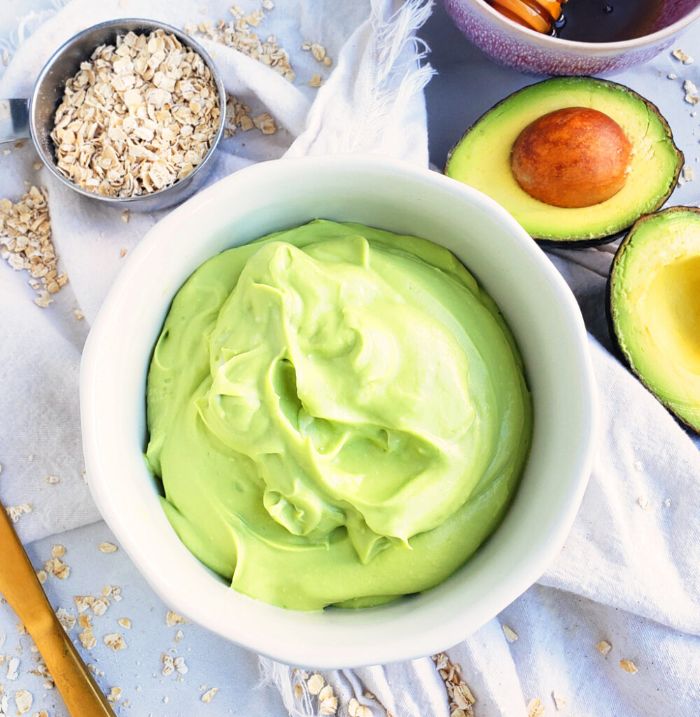 green avocado mask inside white bowl how to make masks at home oats and avocados on the side