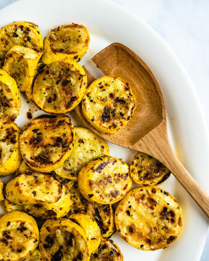 grilled summer squash placed on white plate summer squash recipes wooden spoon on the side