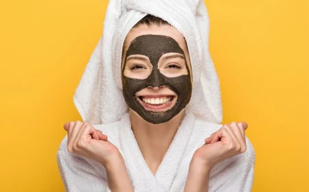 homemade face mask woman wearing face mask white robe and head towel yellow background