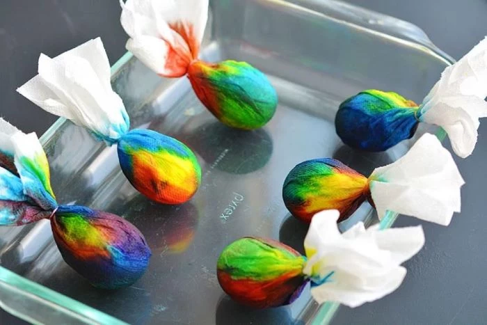 how to color easter eggs six eggs wrapped in paper soaked in different colors placed in glass tray