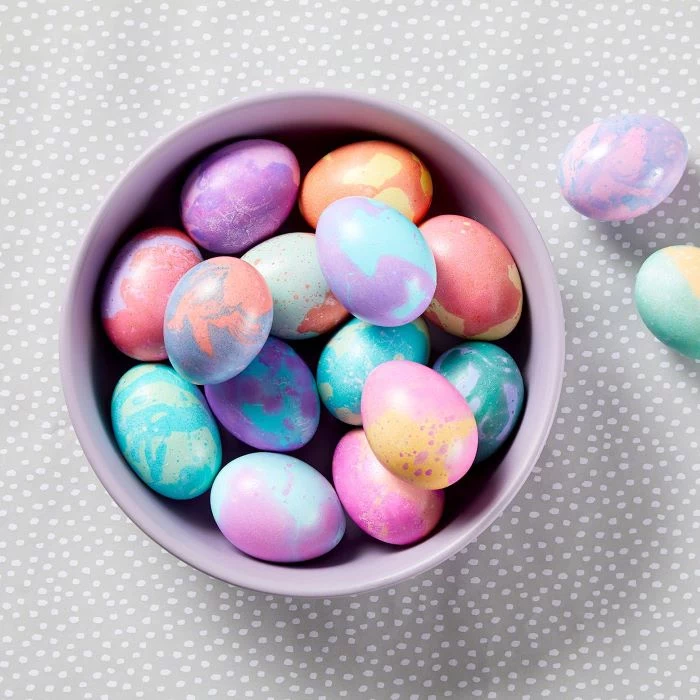 how to dye eggs with food coloring marble eggs decorated in pink purple blue orange yellow in purple bowl