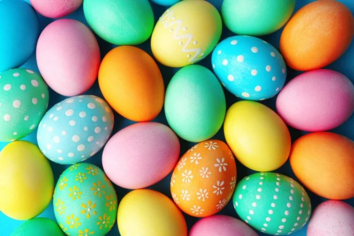 lots of easter eggs placed on blue surface easter egg designs decorated in different colors