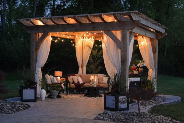lounge area under a gazebo with white curtains and fairy lights home wedding ideas sofa and armchairs