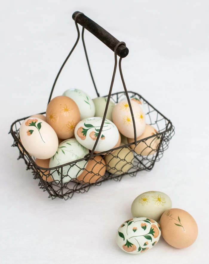 metal basket filled with eggs easter egg coloring different flowers drawn on them