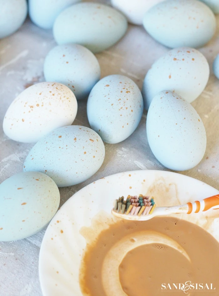 painting the eggs in blue and leaving gold sprays on them easter decorations 2021 step by step diy tutorial