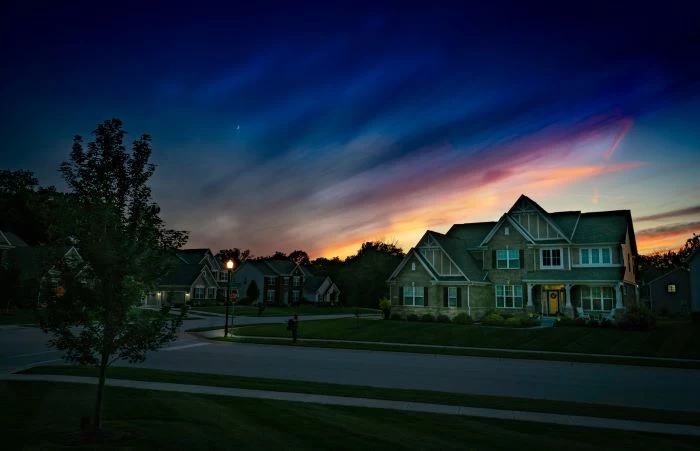 photo of street with large houses on it moving to a new neighborhood dark sky at sunrise