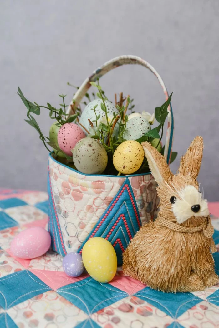 stuffed bunny next to basket made of fabric easter baskets for boys flowers and dyed easter eggs inside