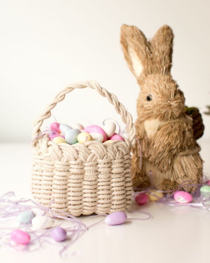 stuffed bunny next to macramé basket adult easter basket filled with egg shaped lights on string