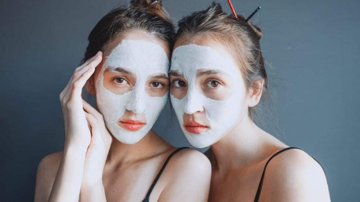 two girls wearing white face masks diy face masks hairs in messy buns