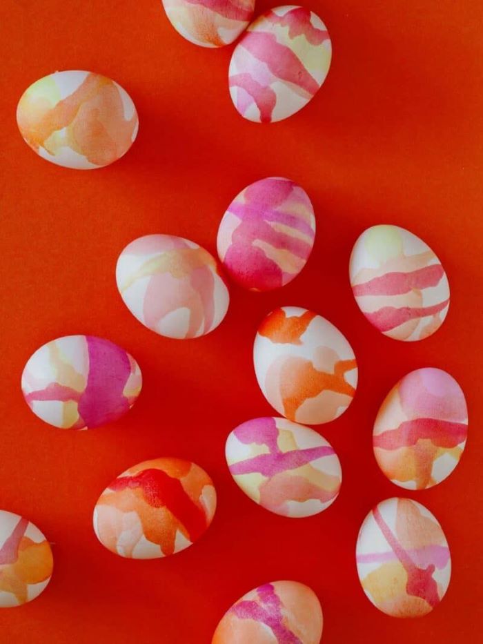 watercolor eggs easter egg decorating ideas arranged on red surface