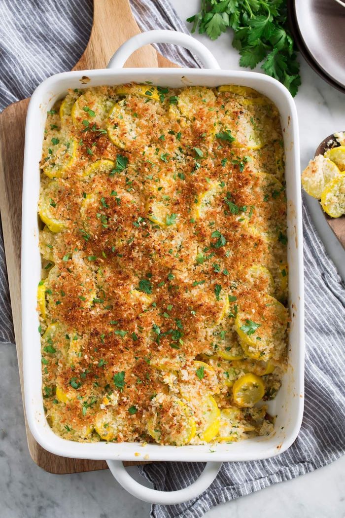 white casserole yellow squash casserole garnished with grated cheese and chopped parsley