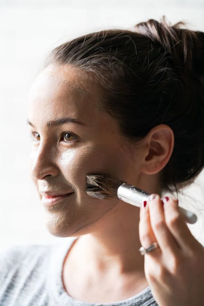 woman putting on mask on her face using a brush how to make a face mask for skin
