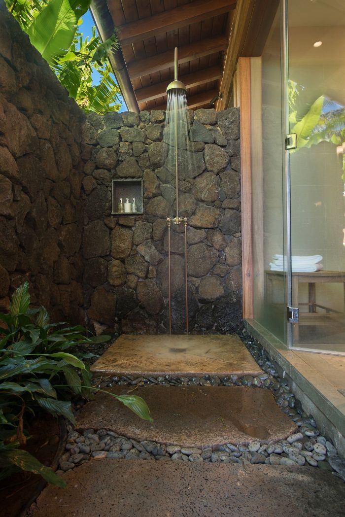 hawaiian style outdoor shower enclosure made of rocks stone tiles and rocks on the floor