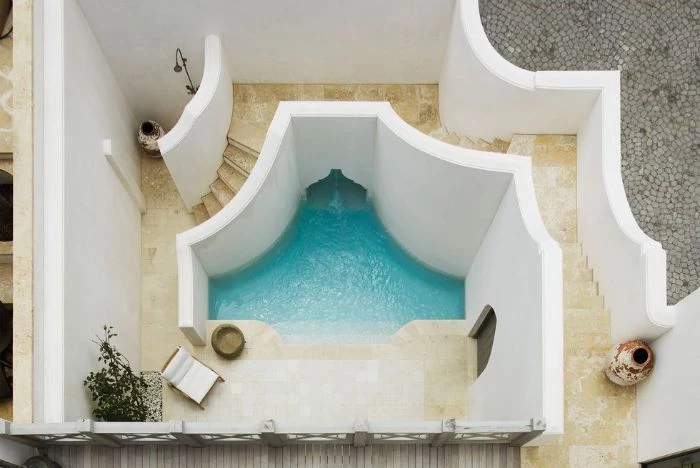 moroccan style pool with lounge chair outside showers white walls tiled floor