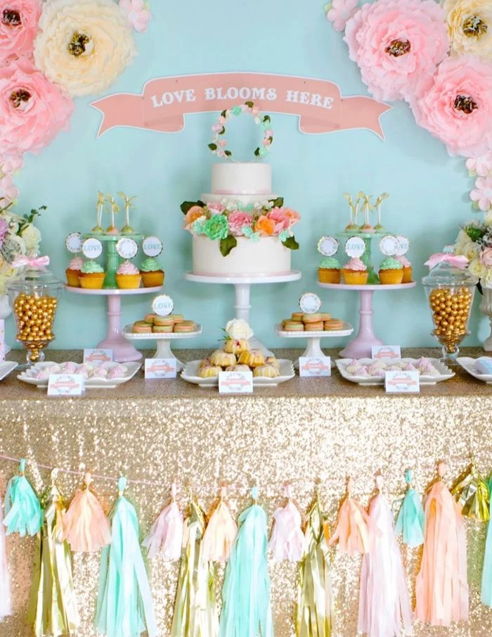 baby shower decorations dessert table with cake stands with cupcakes white cake with flowers paper flowers on the wall
