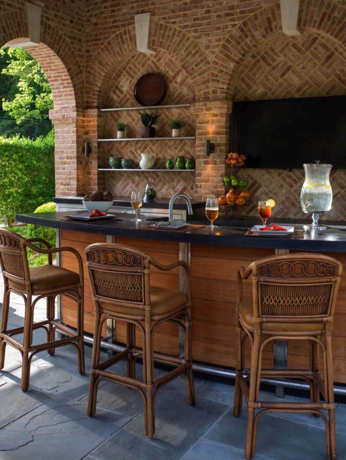 black countertop on wooden kitchen island three chairs in front of it backyard bar ideas shelves on stone wall