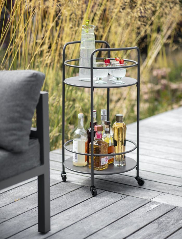 black metal trolley with different bottles and glasses on it outdoor wooden bar