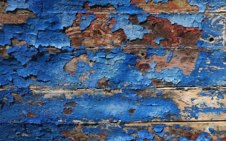 blue paint in pieces coming off of wooden surface lead poisoning close up photo