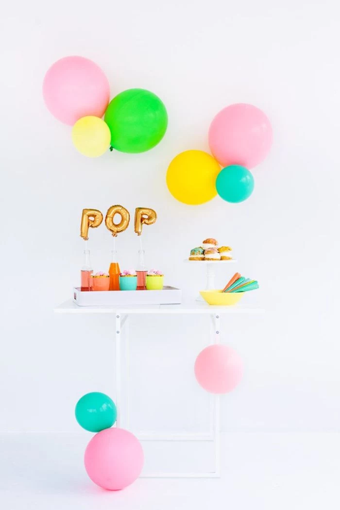 blue pink green yellow balloons over table with donuts and lemonade baby shower decoration ideas pop gold balloons