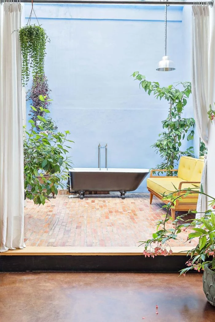 blue wall diy outdoor shower bathtub and sofa surrounded by plants and flowers