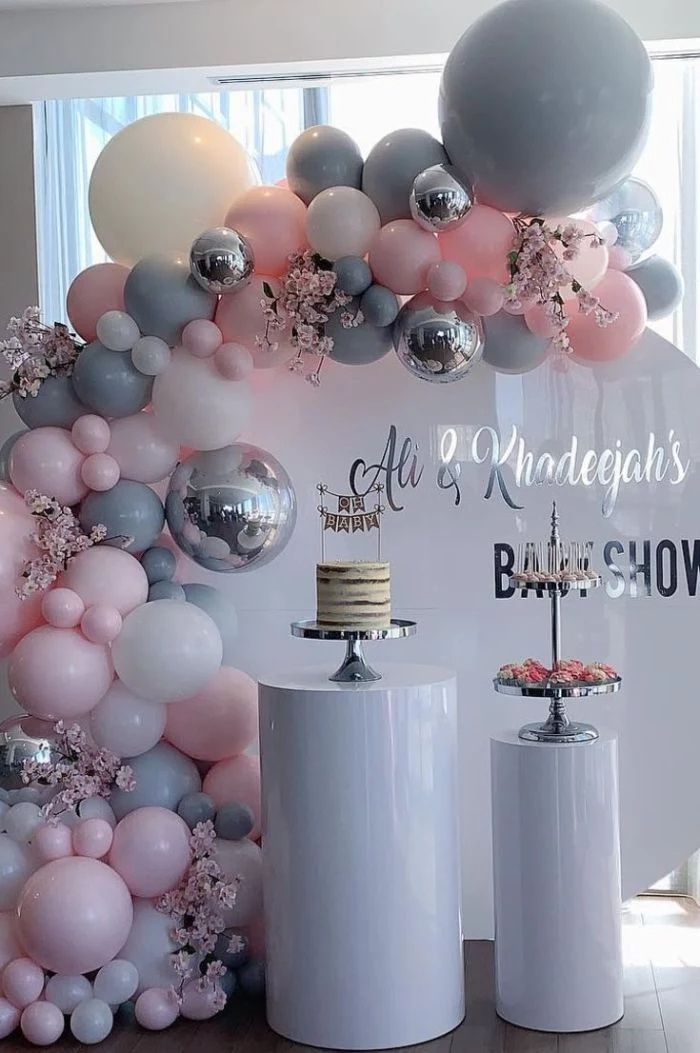 boy baby shower decorations arch made with gray silver pink white baloons cake and cake stand with cupcakes