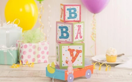 carton centerpiece with baby blocks spelling baby baby shower decorations girl balloons in the background