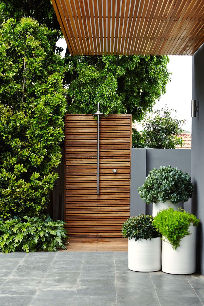 contemporary architecture outside showers wood wall with shower head surrounded by plants and trees