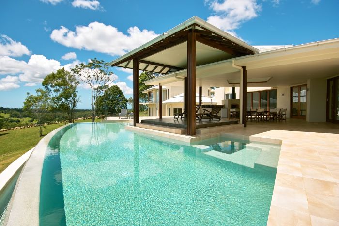 deck with lounge chairs under shade next to large pool backyard inground pools