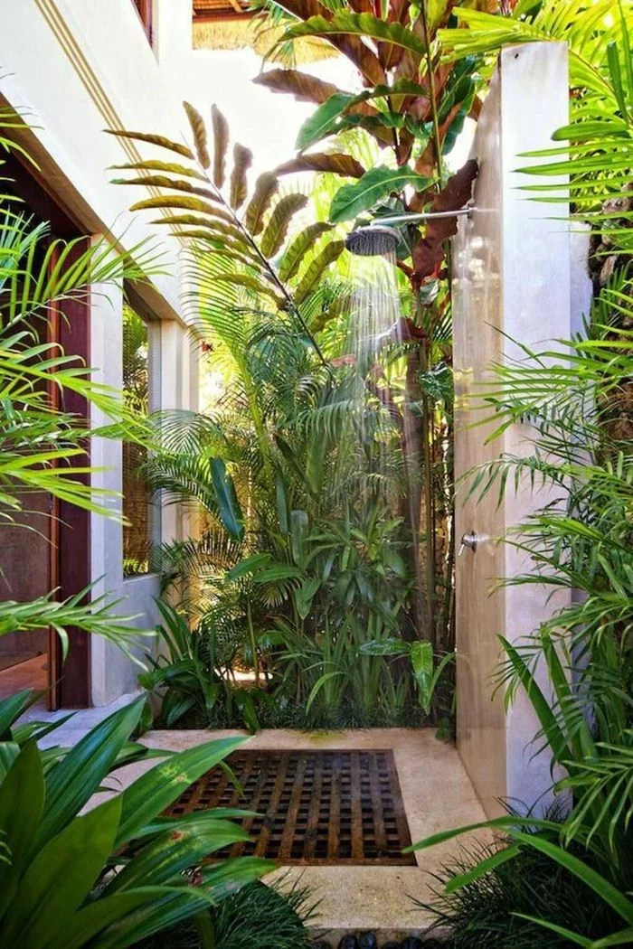 diy outdoor shower enclosure shower mounted on white wall surrounded by plants bushes and trees