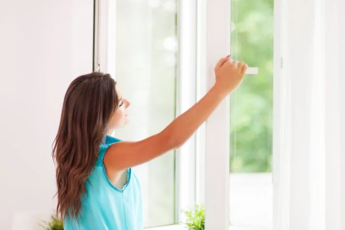 door installation woman with long brown hair wearing blue top opening window