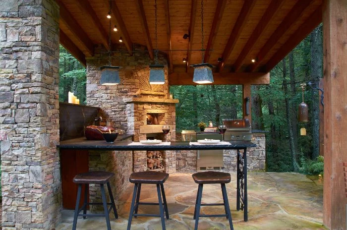enclosure made with stones with fireplace and barbecue backyard bar ideas three bar stools next to bar with black countertop